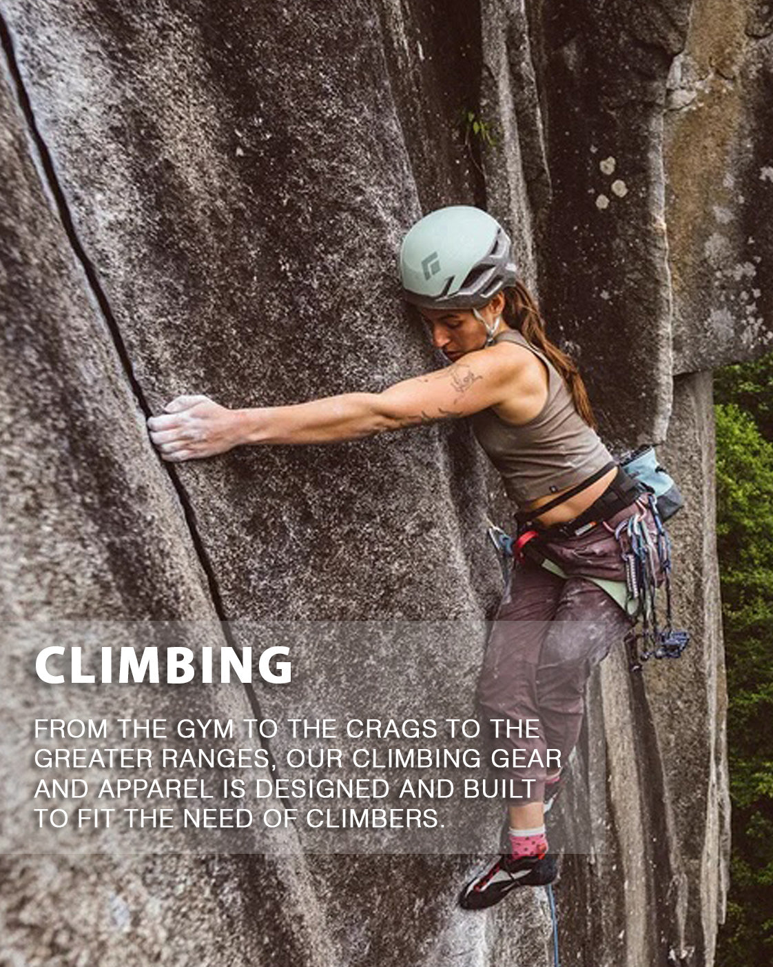 Person climbing a rock wall wearing climbing gear.